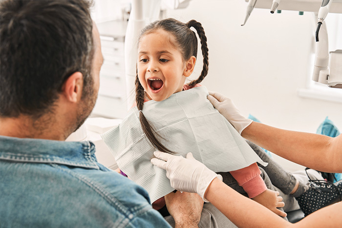 baby girl showing teeth to dentist